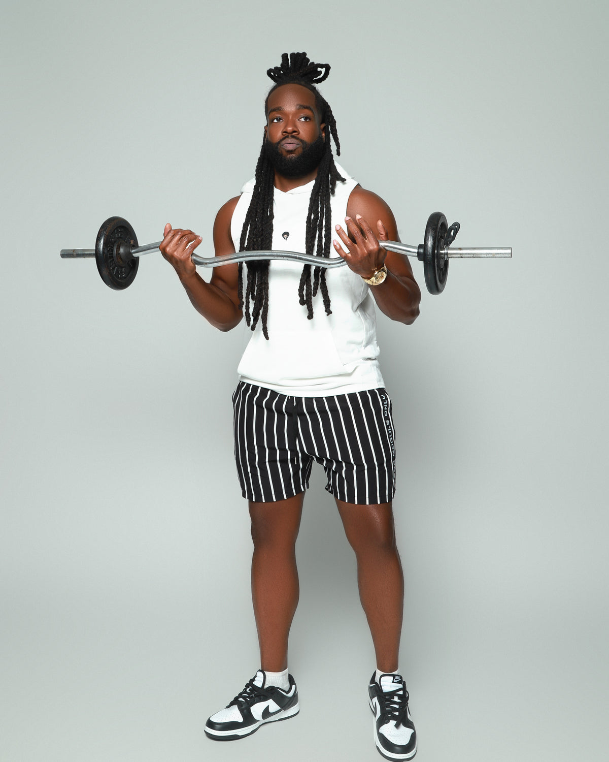 Elevated Coaching by For Moguls Only featuring fitness coach performing barbell curls. Personalized training, nutrition guidance, accountability coaching, and sustainable fitness transformation.
